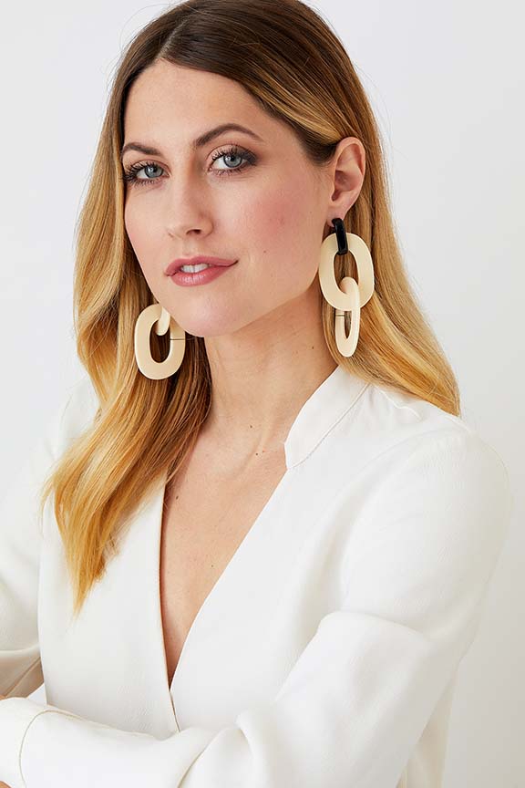 Cream black hoop statement earrings worn by a model in a white blazer