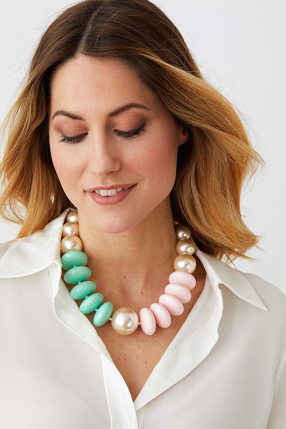 Pearl green pink pastel statement necklace worn by a model in a white collared shirt