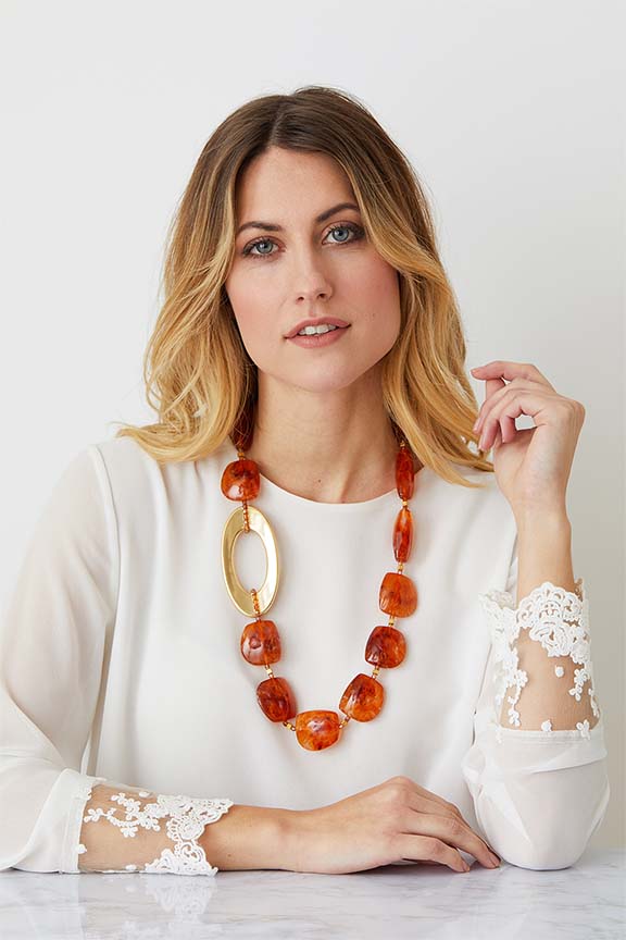 Amber gold statement necklace worn by a model in a lace top