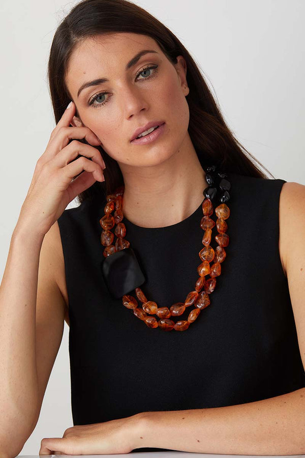 Amber black statement necklace worn by a model in a black evening dress