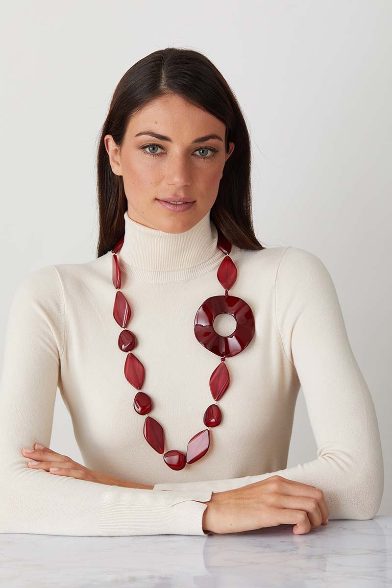 Red ruby statement necklace worn by a model in a white turtleneck