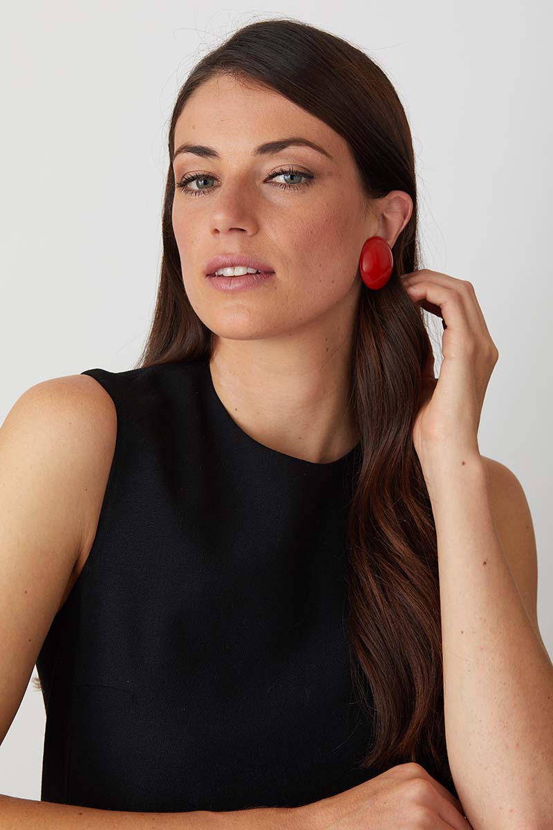 Red resin clip on button statement earrings worn by a model in a black evening dress. Comfort Clips designed by Pietrasanta