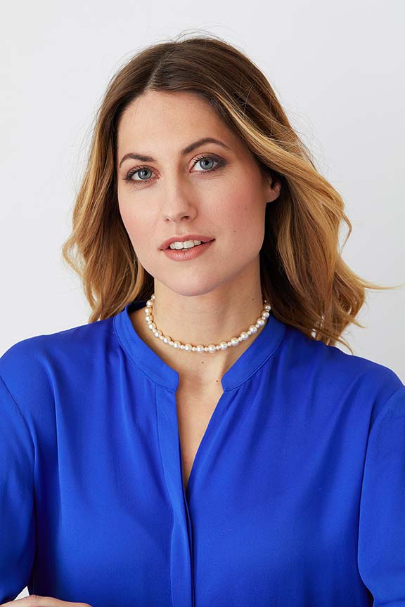 Pearl choker statement necklace worn by a model in a blue shirt