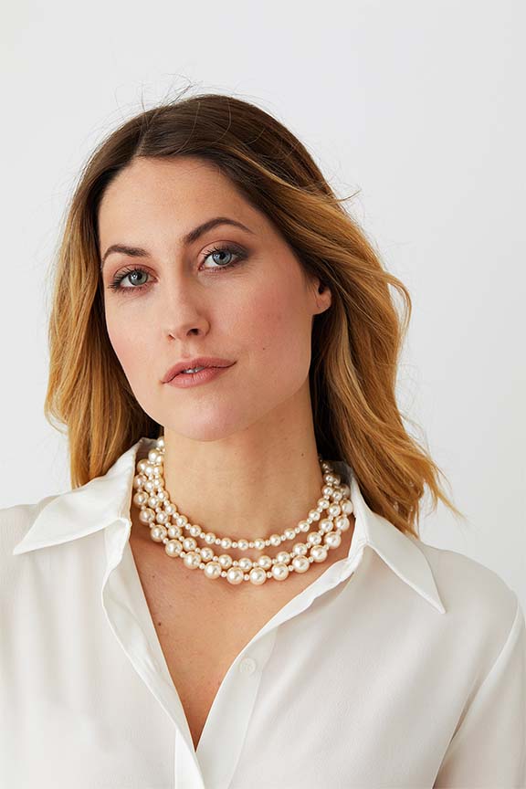 Pearl triple choker statement necklace worn by a model in a white silk collared shirt