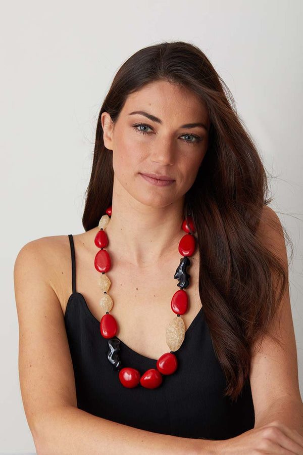 Red coral black statement necklace worn by a model in an elegant black dress