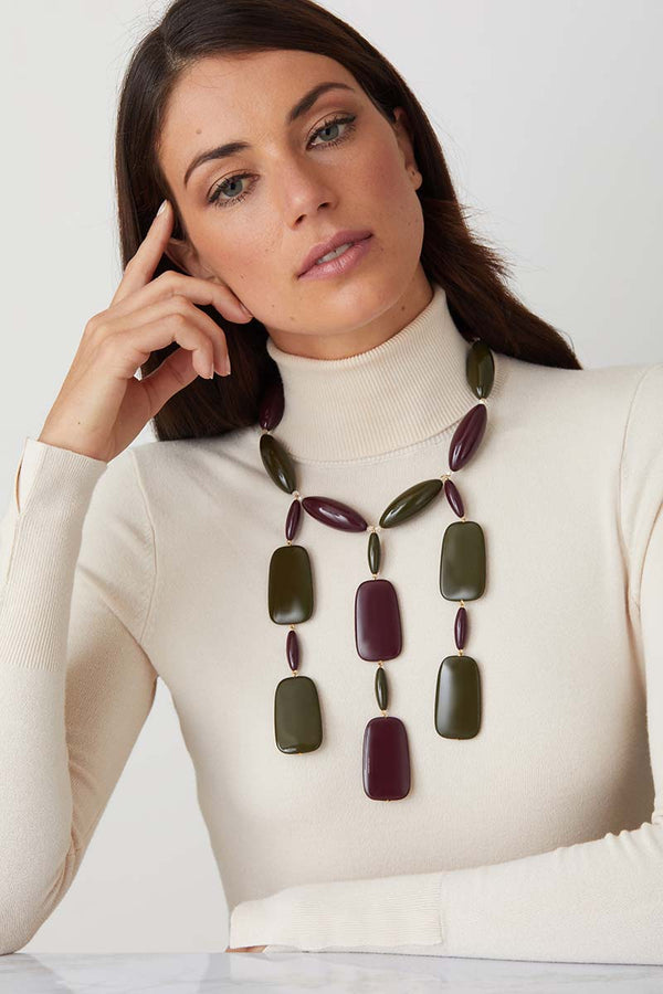 Green burgandy statement necklace worn by a model in a white turtleneck