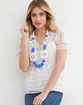 white blue long statement necklace worn by a model in a white lace shirt